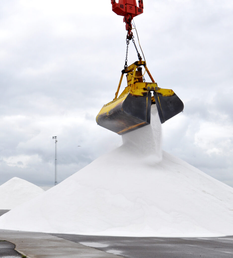 Vägsalt lossas med kranskopa.