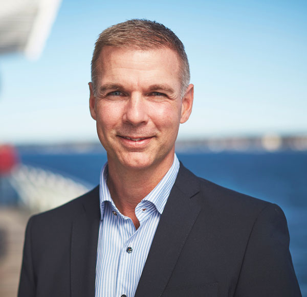 Porträtt Nicklas Romell. Hav och himmel i bakgrunden.