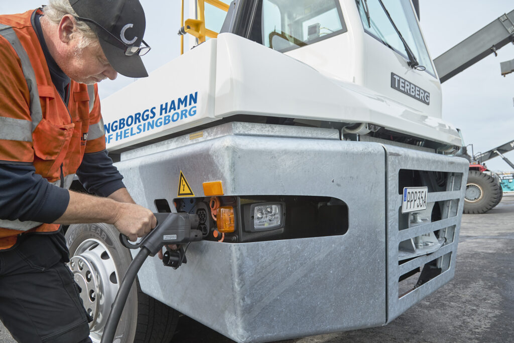 Stuveriarbetare sätter i ladd-kabeln till el-dragbil