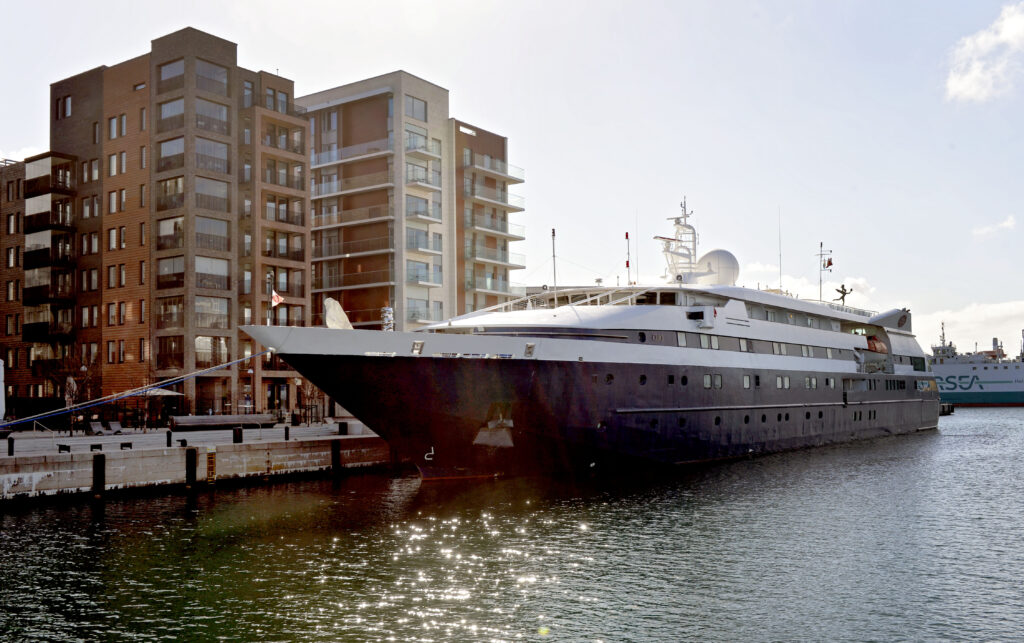 kryssningsfartyg ankrat framför lägenhetsbyggnader. 