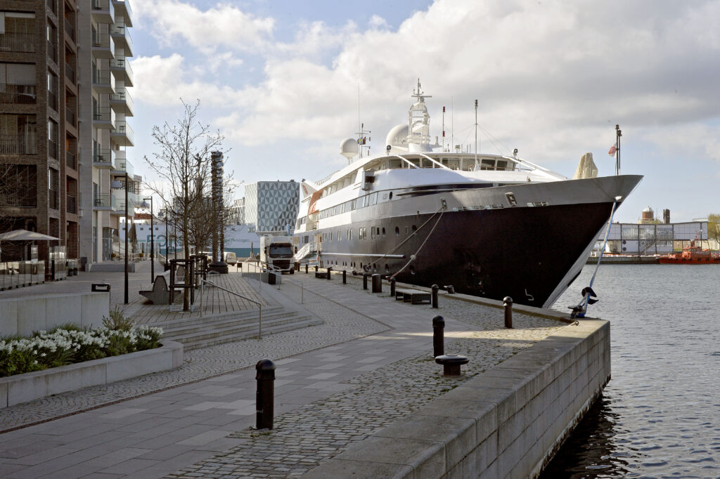 kajpromenad med litet kryssningsfartyg ankrat. 