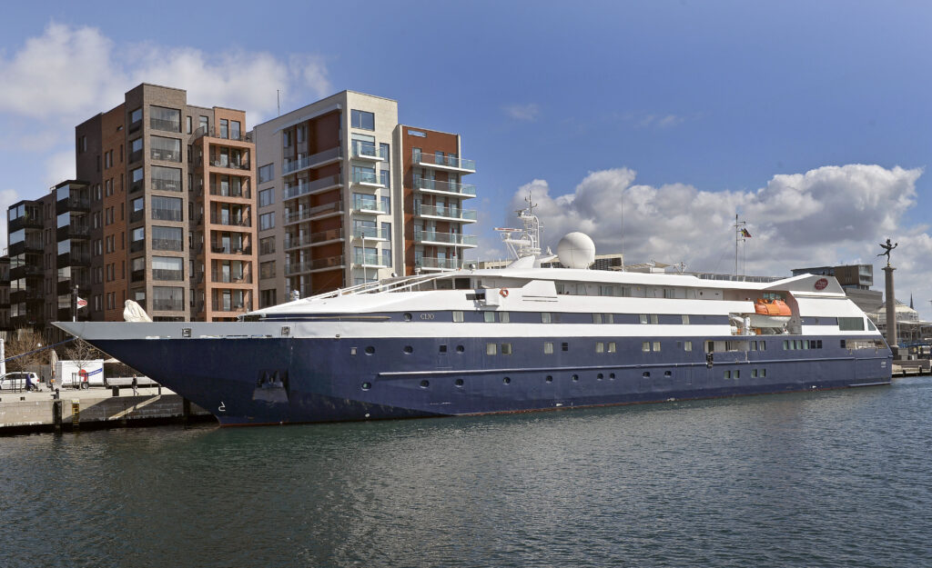 kryssare ligger till kaj framför lägenhetsbyggnader