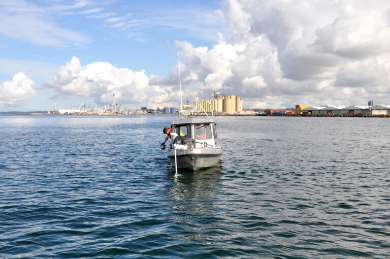 Liten båt med forskare och utrustning ute på Öresund framför hamnen i Helsingborg