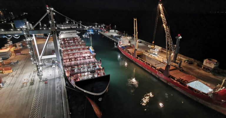The container vessel Dettifoss from Eimskip is moored at the quay under Crane 19 in the Container Terminal at the Port of Helsingborg in the evening, illuminated by ship and terminal lights.