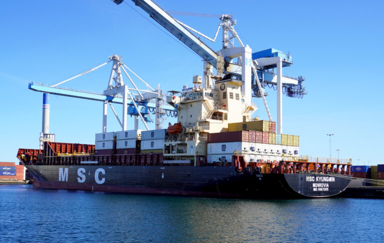 Container vessel MSC Kyungmin alongside at the Port of Helsingborg, with quay cranes positioned over the ship during cargo operations.